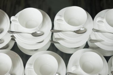 Kahve molası için masada beyaz bardak kahve veya çay kaşık ile yığılmış.