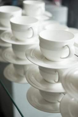 Otelde masada beyaz bardak sıcak bir içecek için yığılmış