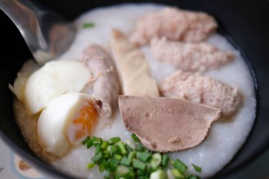 Pirinç lapası pirinç yulaf çorbası congee pirinç çorbası yumurta, karaciğer ve domuz. Kahvaltı gıda kavramı.
