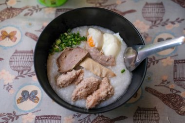 Pirinç lapası pirinç yulaf çorbası congee pirinç çorbası yumurta, karaciğer ve domuz. Kahvaltı gıda kavramı.