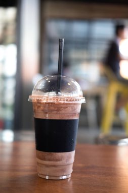 Ahşap tabl üzerinde paket servisi olan restoran Kupası'nda buzlu kakao