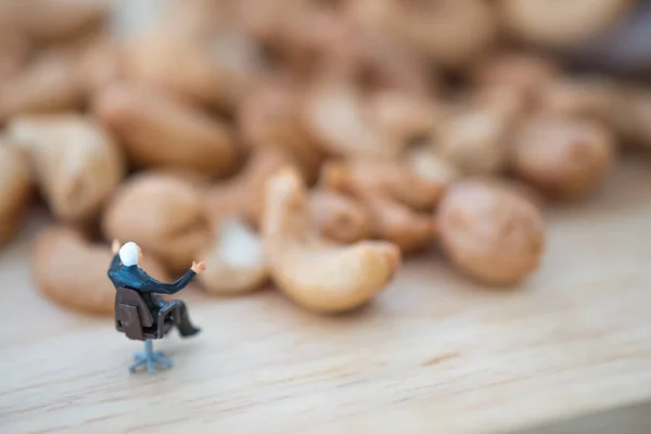 Miniature people businessman selecting best quality cashew for export. Import Export concept