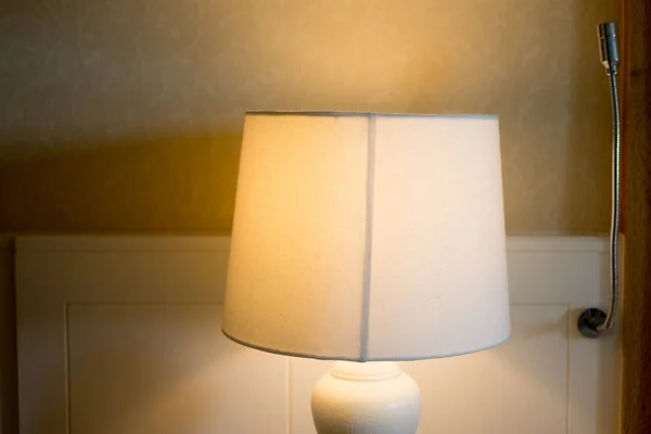 Bedside lamp on night in hotel bedroom