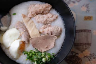 Pirinç yulaf çorbası ile kıyılmış domuz, domuz karaciğer, yumuşak dilimlenmiş yumurta haşlanmış ve zencefil doğranmış