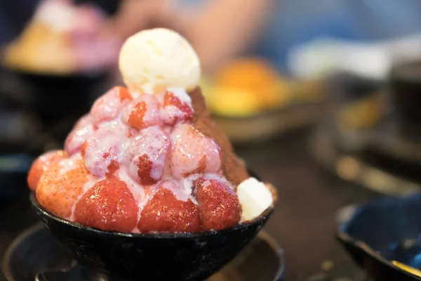 Korean shaved milk ice topped by fresh strawberry. Strawberry cheesecake bingsu