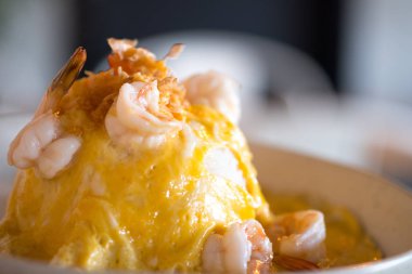 Sahanda yumurta karides pirinç beyaz tabakta servis.