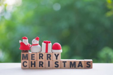 Dekorasyon için oyuncak ile neşeli Noel ahşap bloklar. Noel tatil şenlikli Tema ve metniniz için boş alanı kavramı (kardan adam, hediye kutusu, Santa claus, Noel ağacı ve santa kap)
