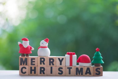 Dekorasyon için oyuncak ile neşeli Noel ahşap bloklar. Noel tatil şenlikli Tema ve metniniz için boş alanı kavramı (kardan adam, hediye kutusu, Santa claus, Noel ağacı ve santa kap)