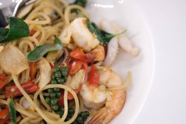 Baharatlı karışık deniz ürünleri beyaz bir tabak spagetti