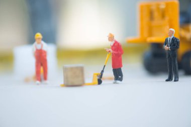 Minyatür iş adamı dağıtım depo fabrika ürünleri mal taşıyan işçilerin bak. Kargo ve nakliye kavramı