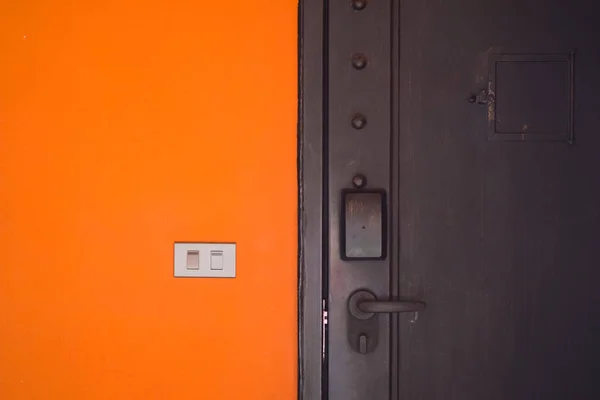 Διακόπτη Ηλεκτρικής Ενέργειας Πορτοκαλί Τσιμεντένιο Τοιχίο Και Μαύρο Πόρτα — Φωτογραφία Αρχείου