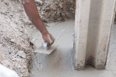 Islak Beton inşaat sahasında yayılan inşaat işçisi.