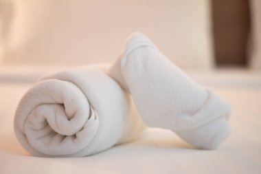 Beyaz havlu rulo beyaz yatakta kapatın