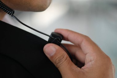 Erkek güvenlik görevlisi taşınabilir radyo açık havada (kendinden emin güvenlik kullanarak Close-up)