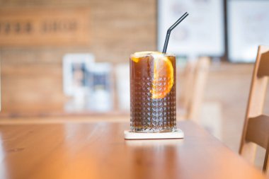 Kahve masada cam dilim portakal ile portakal suyu ile karıştırın. Seçici odak (Fusion içki)