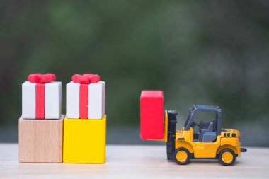 Bir oyuncak forklift kamyon Hediyelik kutu teslim. Hediye teslimat kavramı