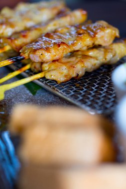 Satay dilimlenmiş domuz karışık sarı baharatlarla yapılan Tay meze, pişmiş ve bir ızgara koyun kadar kızartma
