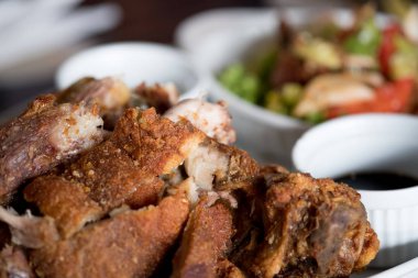 Bir tabakta sebze ve baharat soslu çıtır çıtır kızarmış domuz bacak yerleştirilir