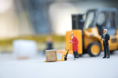 Minyatür iş adamı dağıtım depo fabrika ürünleri mal taşıyan işçilerin bak. Kargo ve nakliye kavramı