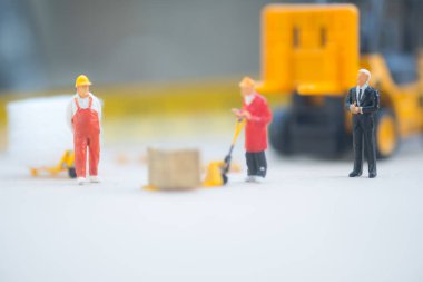 Minyatür iş adamı dağıtım depo fabrika ürünleri mal taşıyan işçilerin bak. Kargo ve nakliye kavramı