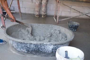 Beton kum çimento ve inşaat işçileri grunge çimento tepsi açık sitesinde su dökme suyla adım karıştırma.
