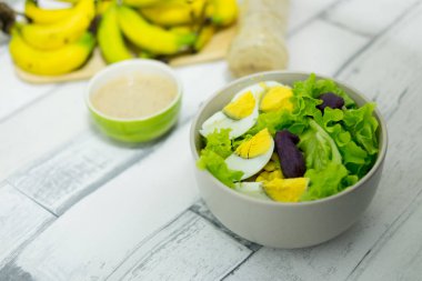 Taze meyve ve salata sosu ile taze sebze salatası (marul, yam ve haşlanmış yumurta). sağlıklı gıda kavramı