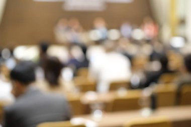 Bulanık görüntü eğitim insanlar ve iş adamları için seminer konferans salonunda oturuyor