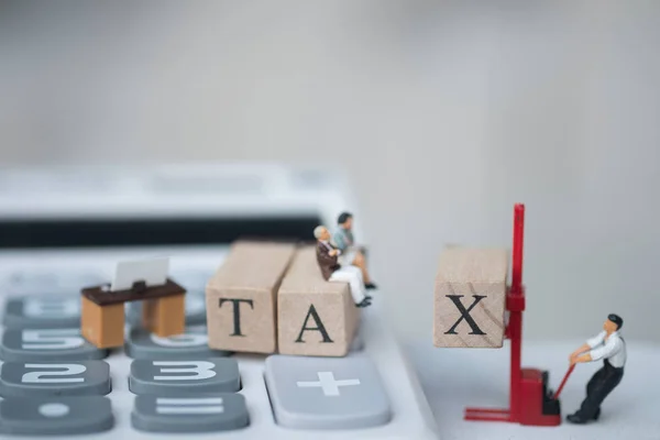 Miniaturmenschen Sitzen Auf Holzbuchstaben Die Auf Taschenrechnern Platziert Sind Jahreseinkommen — Stockfoto