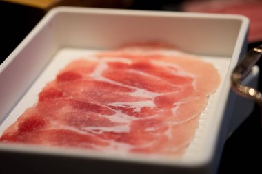 Beyaz bir plaka üzerinde domuz omuz portre kırmızı ham dilimlenmiş