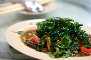 Stir-fried basil leave with fried preserved egg. Thai style food.