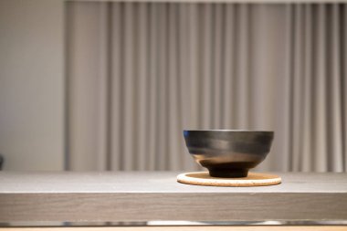 Ahşap mutfak masasında üzerine boş siyah kase görünümünü kapat