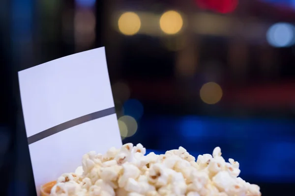 Close up popcorn and movie paper tickets with light mall background