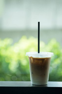 Fincan yeşil doğa arka plan üzerinde buzlu latte ile götürün