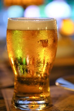 Bir bardak bira ile gece barda renkli ışık