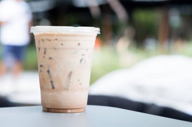 Kapı kahve dükkanı dışarı bir tabloda bir plastik bardak buzlu kahve