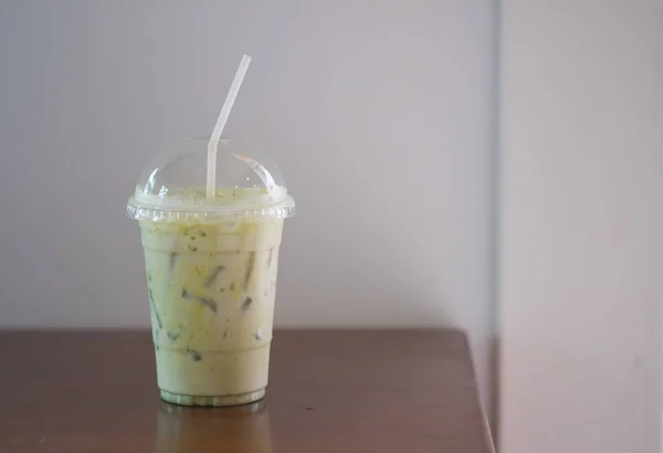 Green tea milk latte with ice in plastic cup or iced Matcha latte tea with milk take away