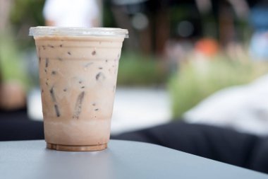 Kapı kahve dükkanı dışarı bir tabloda bir plastik bardak buzlu kahve