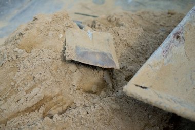 Kürek kum inşaat işi için bir yığın yerleştirilir. Şantiyede iş kavramı