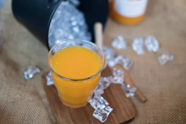 Glass of fresh pressed orange juice served with ice cubes