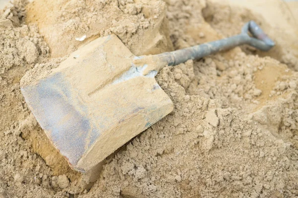 Shovel on a pile of sand for construction work. Concept work at the construction site