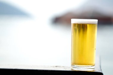 Taze bira doğa arka plan ile masada uzun cam