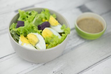 Taze marul salatası yam ve salata sosu ile haşlanmış yumurta. Sağlıklı gıda kavramı