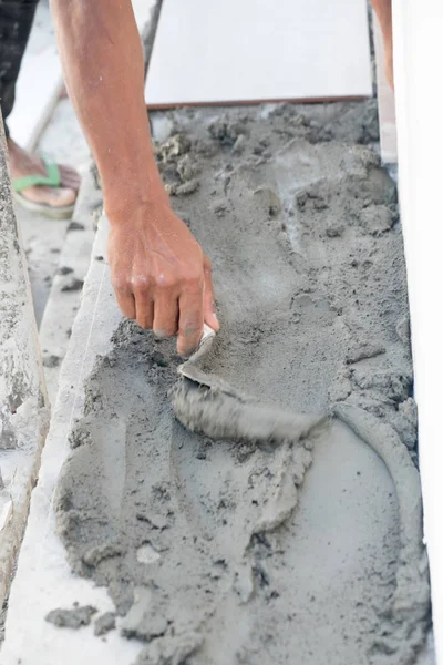 Hands of manual worker with plastering tools renovating house. C