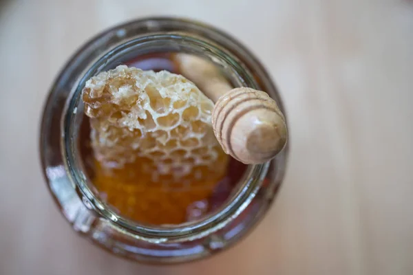Färsk gyllene honung söt med honeycomb och trä honung drippin — Stockfoto