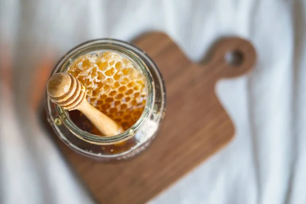 Färsk gyllene honung söt med honeycomb och trä honung drippin — Stockfoto