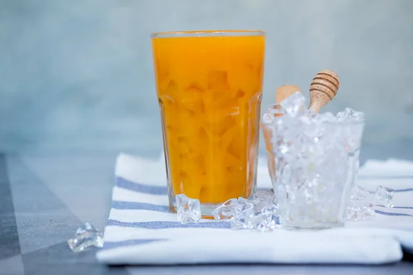 オレンジジュースのグラスにアイスキューブ — ストック写真