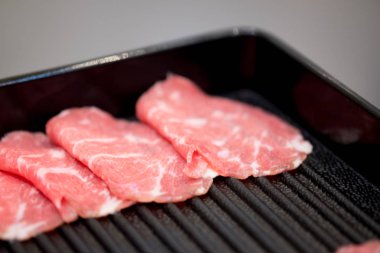 Siyah tepsi üzerinde taze dilimlenmiş sığır eti