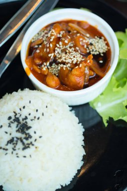 Sos ile kızarmış domuz eti karıştırın ve susam pirinç ile servis