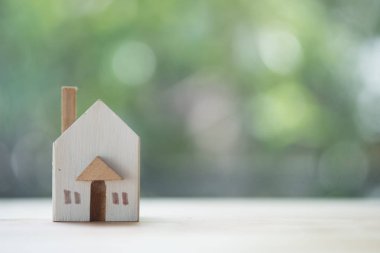 Doğa arka planda minyatür ahşap oyuncak ev. Yeni hous satın alma