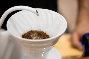 Barista çekilmiş kahve filtresi ile üzerine su dökerek.